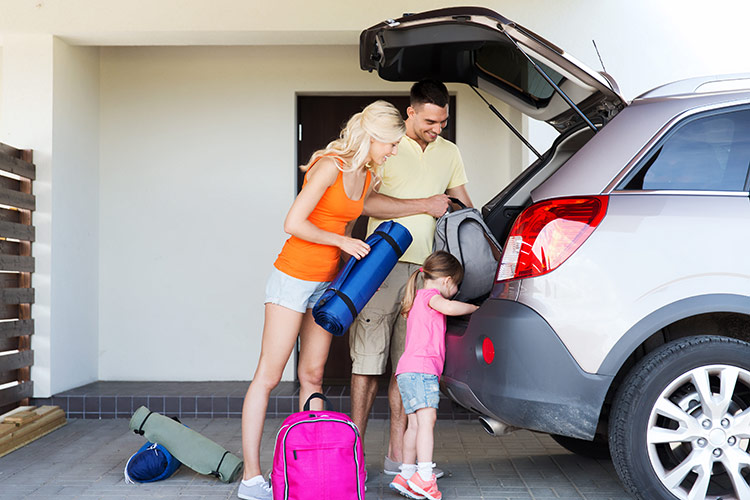 a family packing the boot of a car with belongings