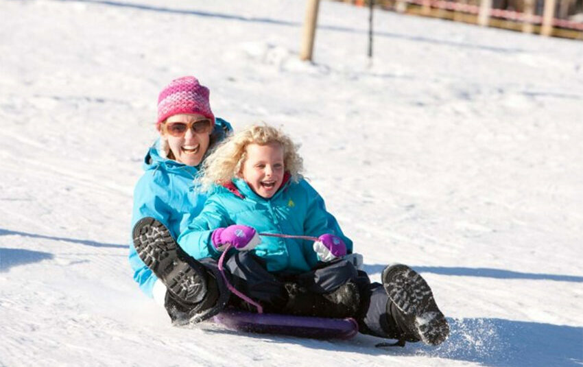 mother and daughter tobogganing