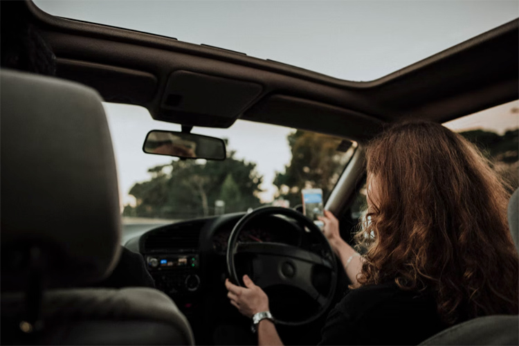 woman-driving-a-car a woman sitting in the front seat of a car driving