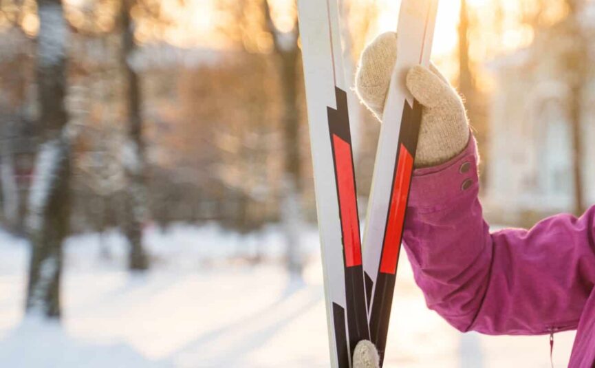 A woman holding a pair of skis