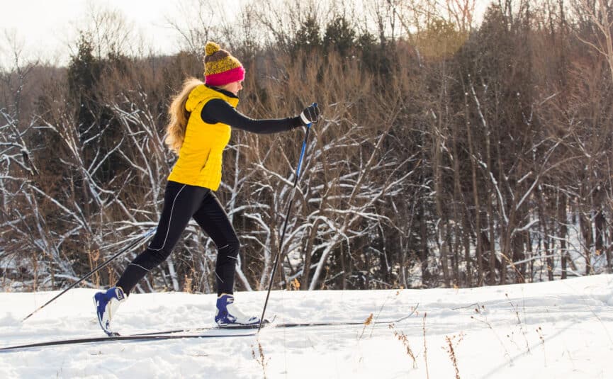 Young woman in yellow jacket cross countryskiing