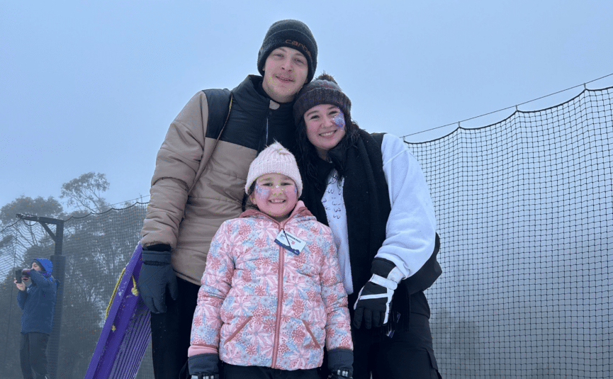 family in the snow with a toboggan